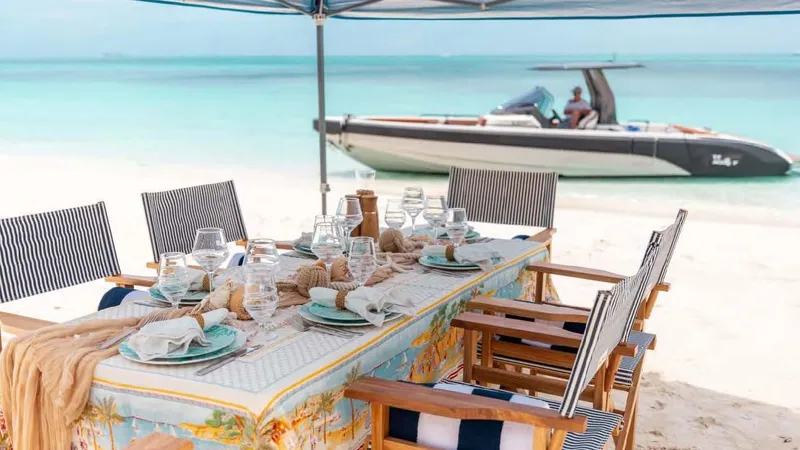 Mercy Yacht Photos Pics Beachfront dining setup with elegant tableware, overlooking a Sunseeker 37 Metre Yacht, 2009 model.