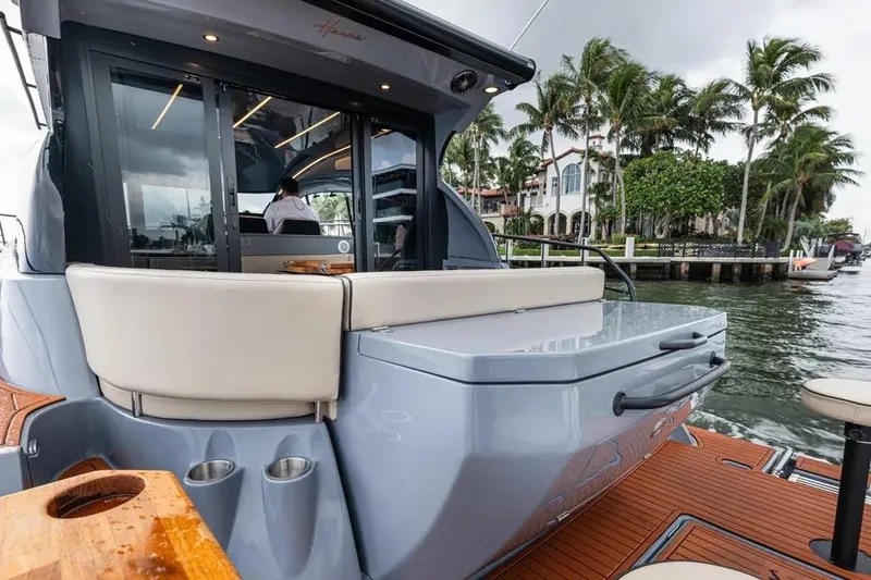  Yacht Photos Pics Luxurious 2026 Hanover 415 yacht with sleek design, docked near palm trees and waterfront homes.