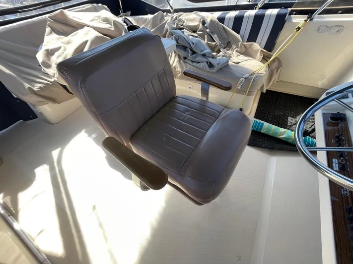 Nowhere Fast Yacht Photos Pics Captain's chair on 2005 Mainship 430 Aft Cabin 3SR Trawler, with striped seating area.