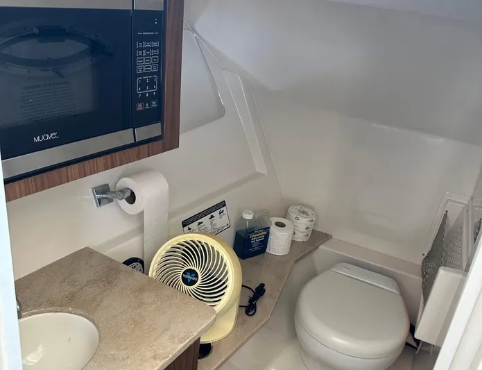  Yacht Photos Pics 2018 Sailfish 325 DC boat bathroom with sink, toilet, fan, and microwave.