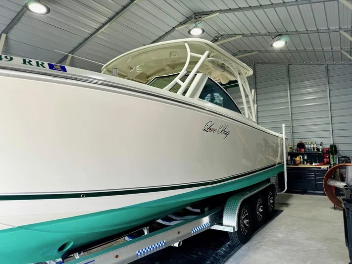  Yacht Photos Pics 2018 Sailfish 325 DC boat in a garage, on a trailer, under bright lighting.