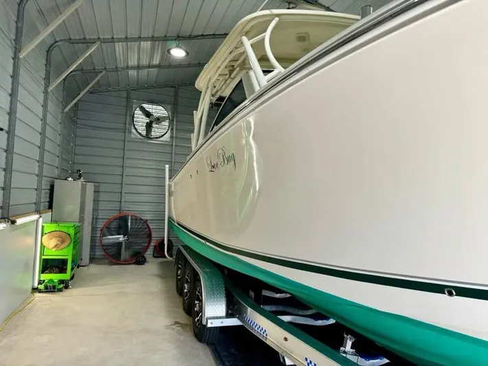  Yacht Photos Pics 2018 Sailfish 325 DC boat in storage, side view, inside a metal garage.