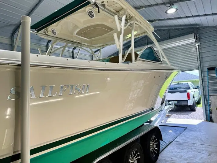  Yacht Photos Pics 2018 Sailfish 325 DC boat in garage, white and green, on trailer.