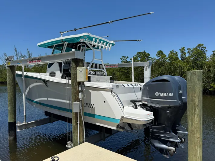  Yacht Photos Pics 2021 Blackfin 272 CC boat with Yamaha engine on a lift by the water.