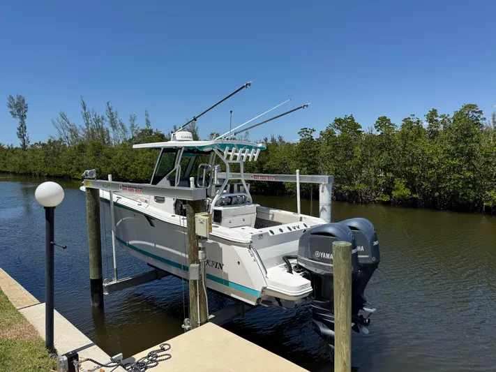  Yacht Photos Pics 2021 Blackfin 272 CC boat docked on a lift by a canal.