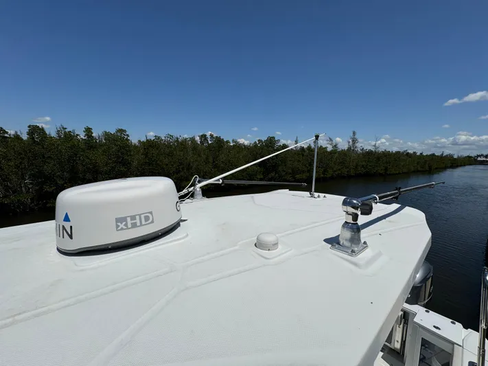 Yacht Photos Pics 2021 Blackfin 272 CC boat roof with radar and antenna, cruising on a river under clear skies.