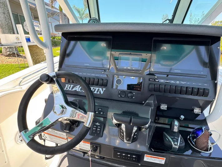  Yacht Photos Pics 2021 Blackfin 272 CC boat dashboard with steering wheel and electronic controls.