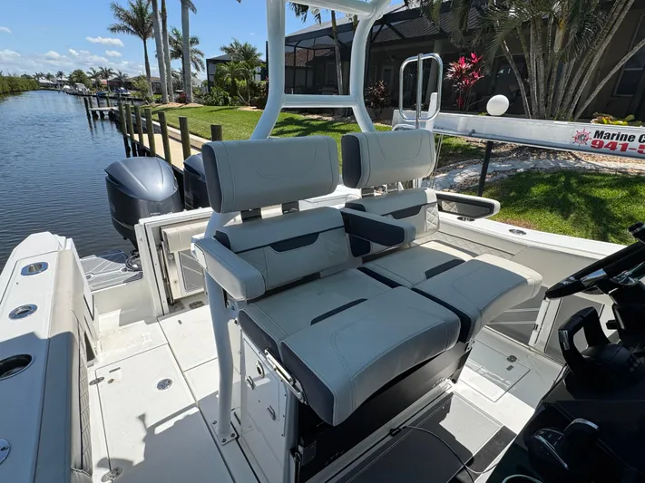  Yacht Photos Pics 2021 Blackfin 272 CC boat interior with comfortable seating by a scenic waterfront.