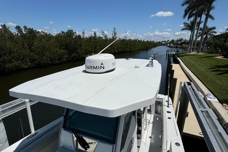  Yacht Photos Pics 2021 Blackfin 272 CC boat with Garmin radar, docked by a scenic waterway.