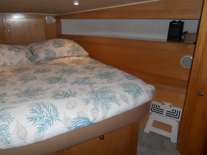 Lucky Yacht Photos Pics Cozy bedroom in 2001 Californian 39 yacht with patterned bedding and wooden interior.