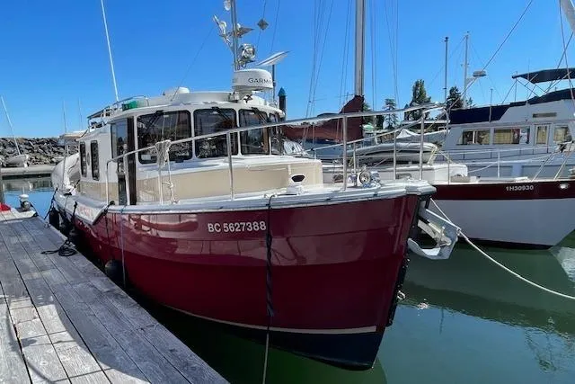  Yacht Photos Pics 2017 Ranger Tugs R-31 S docked in a marina, featuring a red hull and modern design.