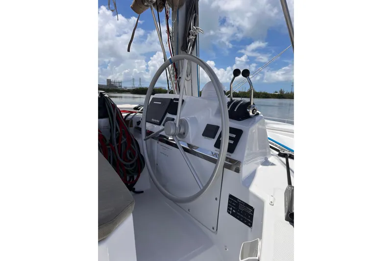 Tamboo Yacht Photos Pics Helm of 2023 Bali 4.2 catamaran with steering wheel and controls, under blue sky.