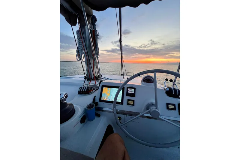 Tamboo Yacht Photos Pics Cockpit view of 2023 Bali 4.2 yacht at sunset, featuring navigation equipment and ocean horizon.