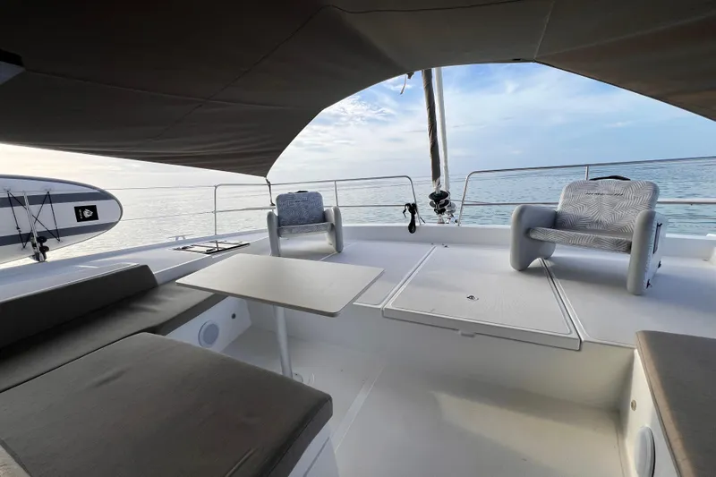 Tamboo Yacht Photos Pics Luxurious Bali 4.2 catamaran deck with seating, table, and ocean view, 2023 model.
