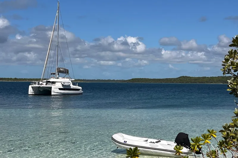 Tamboo Yacht Photos Pics A 2023 Bali 4.2 catamaran anchored in clear blue waters under a sunny sky.