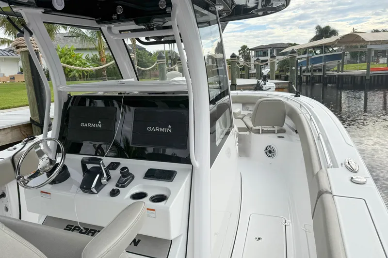  Yacht Photos Pics 2023 Sportsman Open 322 Center Console boat with Garmin navigation, docked by a waterfront.