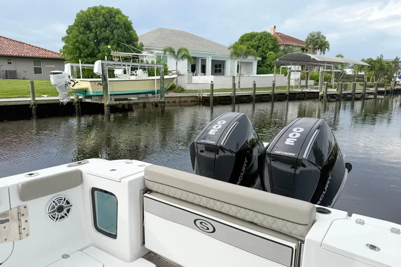  Yacht Photos Pics 2023 Sportsman Open 322 Center Console with twin Mercury engines docked by waterfront homes.