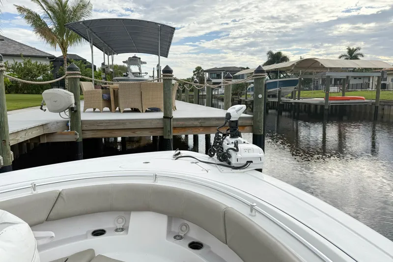  Yacht Photos Pics 2023 Sportsman Open 322 Center Console boat docked by a scenic waterfront.