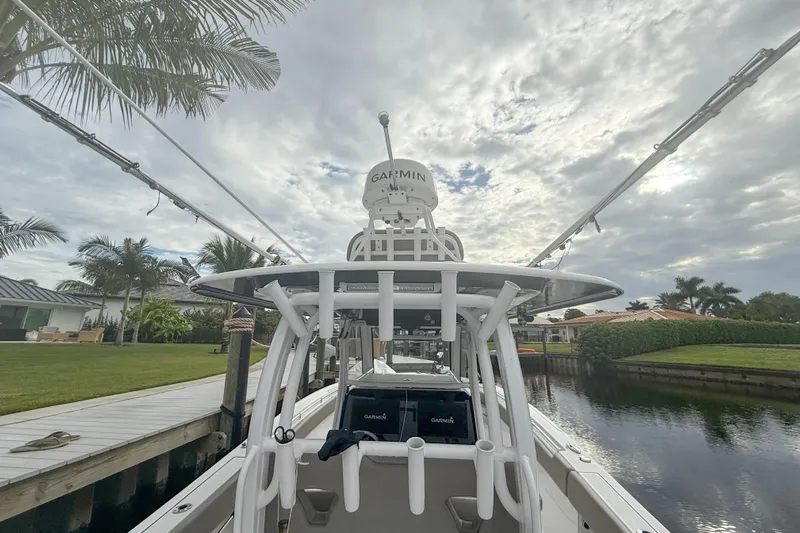  Yacht Photos Pics 2023 Sportsman Open 322 Center Console boat docked by a canal under cloudy skies.