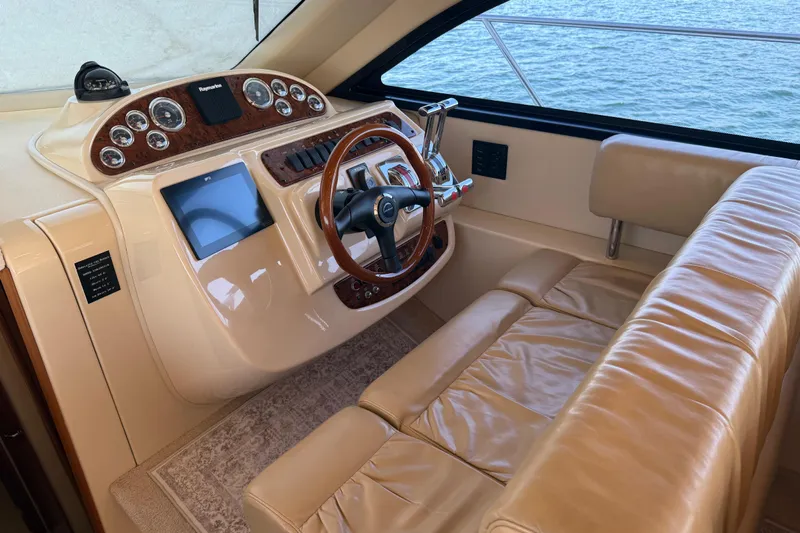  Yacht Photos Pics 2004 Meridian 411 Sedan helm with leather seating and wood-accented controls, overlooking water.