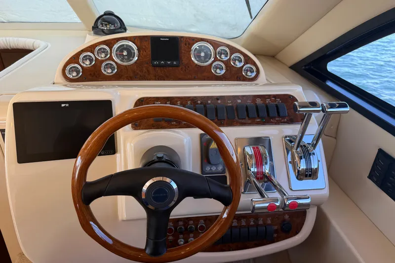  Yacht Photos Pics 2004 Meridian 411 Sedan helm with wood accents and modern controls.