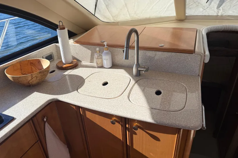  Yacht Photos Pics Luxurious 2004 Meridian 411 Sedan yacht kitchen with modern sink and wooden cabinetry.