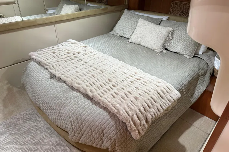  Yacht Photos Pics Luxurious bedroom interior in a 2004 Meridian 411 Sedan yacht, featuring elegant bedding.