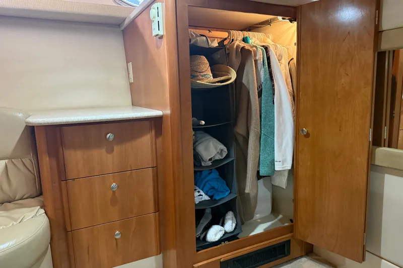  Yacht Photos Pics Wooden closet with clothes and accessories inside a 2004 Meridian 411 Sedan yacht.