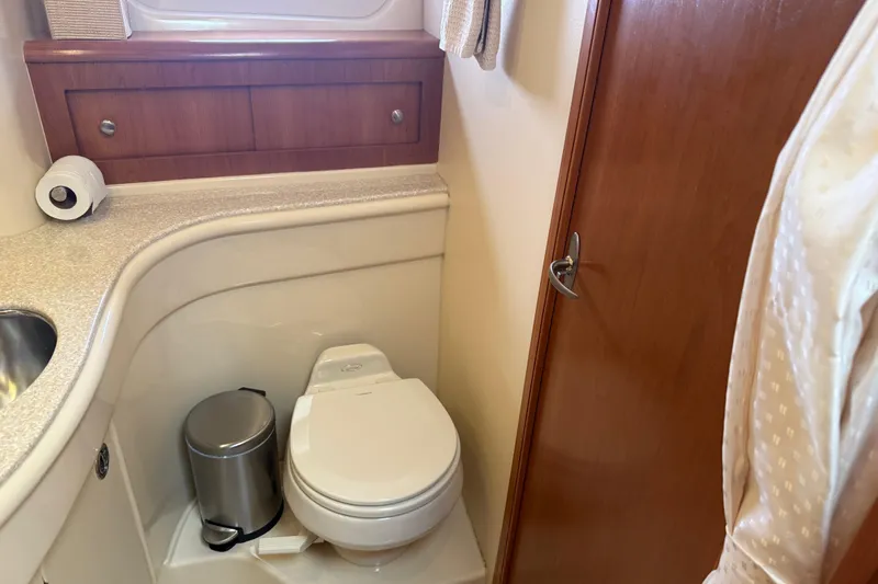  Yacht Photos Pics Bathroom interior of 2004 Meridian 411 Sedan yacht, featuring toilet and wooden cabinetry.
