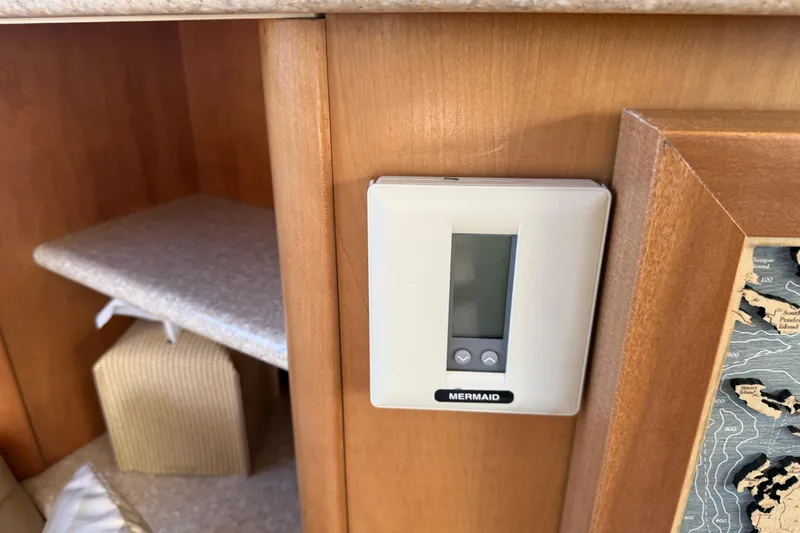  Yacht Photos Pics Thermostat control panel inside 2004 Meridian 411 Sedan boat interior, mounted on wooden wall.
