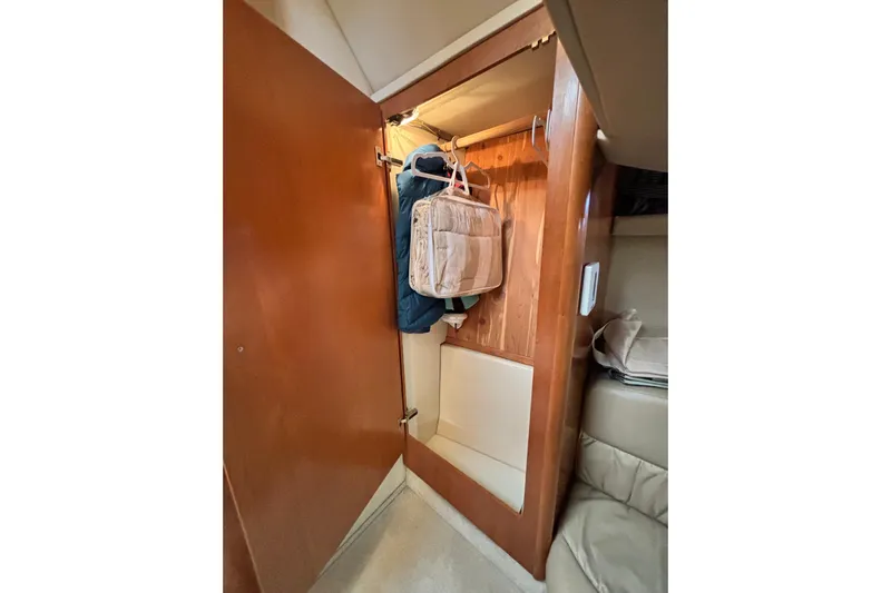  Yacht Photos Pics Wooden closet interior on 2004 Meridian 411 Sedan yacht, featuring hanging clothes and storage.