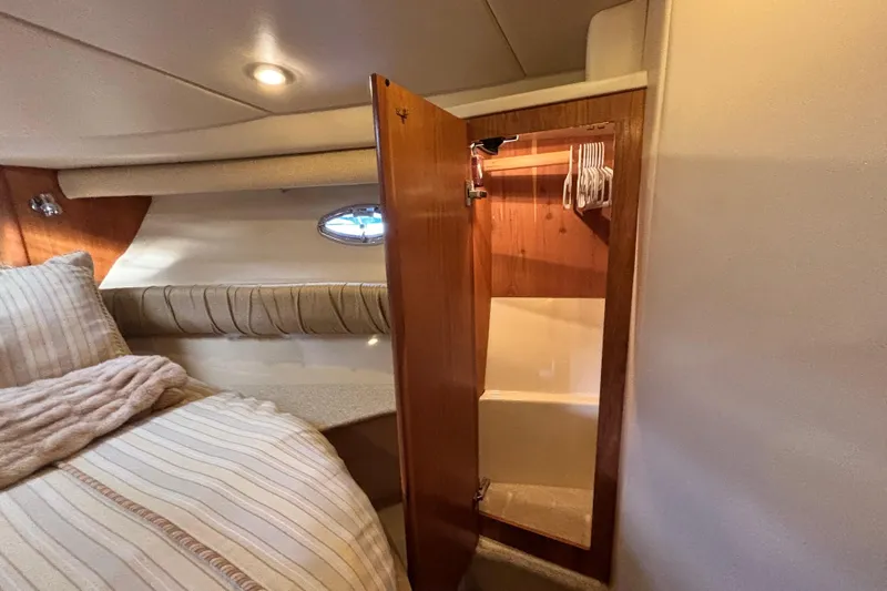  Yacht Photos Pics 2004 Meridian 411 Sedan interior with open wooden closet and cozy bed.