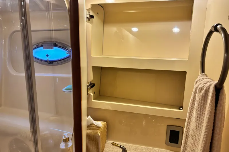  Yacht Photos Pics 2004 Meridian 411 Sedan bathroom with open cabinet, towel rack, and porthole window.
