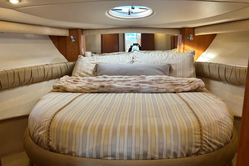  Yacht Photos Pics Luxurious bedroom interior of 2004 Meridian 411 Sedan yacht with plush bedding and porthole.