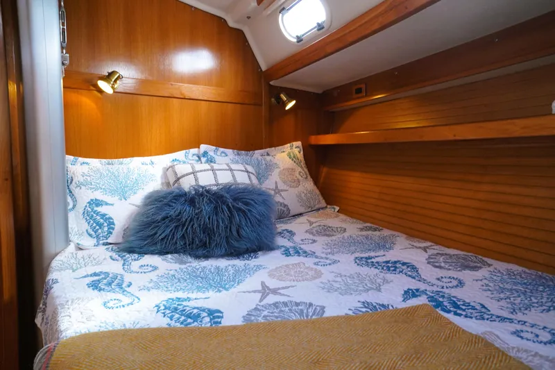 Alola Yacht Photos Pics Cozy cabin interior of 2003 Catalina 42 MkII sailboat with nautical-themed bedding.
