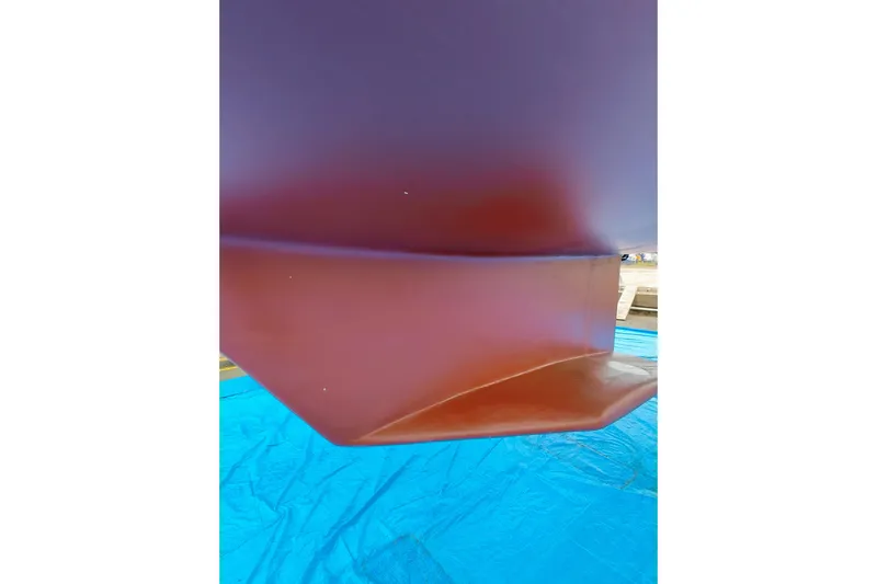 Alola Yacht Photos Pics Close-up of 2003 Catalina 42 MkII boat hull on blue tarp.