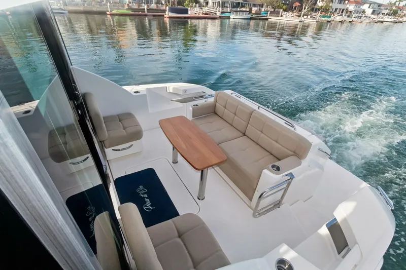 Pour It On Yacht Photos Pics 2017 Tiara Yachts C39 Coupe, elegant deck seating with table, cruising on calm waters.