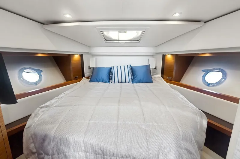 Pour It On Yacht Photos Pics Luxurious bedroom interior of 2017 Tiara Yachts C39 Coupe with elegant bedding and porthole windows.