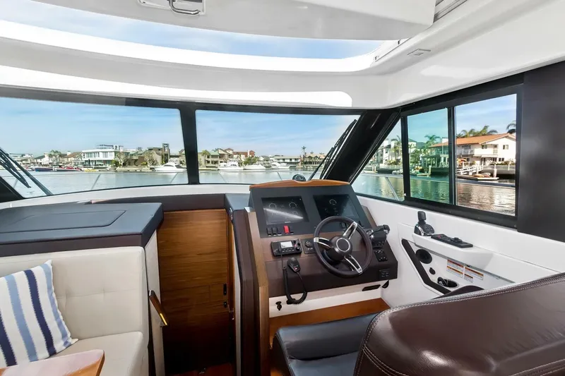 Pour It On Yacht Photos Pics Interior view of 2017 Tiara Yachts C39 Coupe helm with waterfront background.