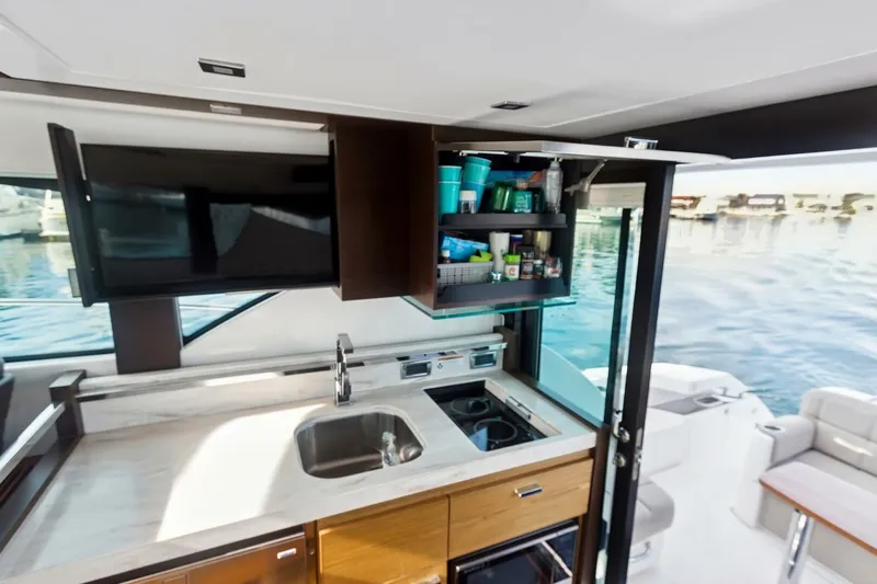 Pour It On Yacht Photos Pics Modern kitchen area on 2017 Tiara Yachts C39 Coupe with open cabinet and sink.