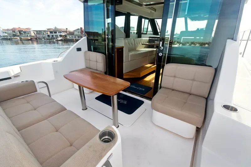 Pour It On Yacht Photos Pics 2017 Tiara Yachts C39 Coupe interior with seating and table, overlooking waterfront homes.