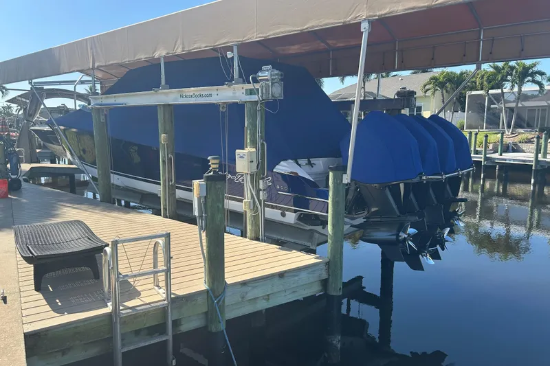  Yacht Photos Pics 2024 Nor-Tech 400 Supersport boat docked with blue covers, under a canopy.