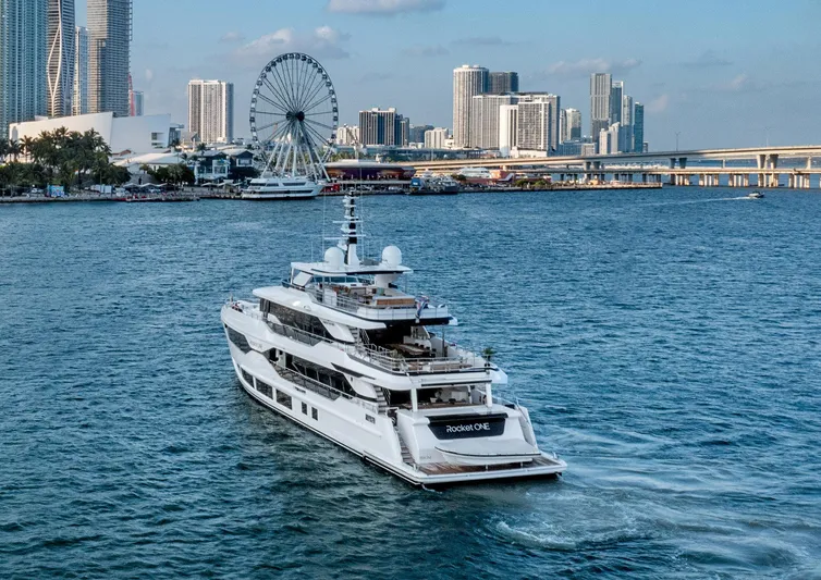 Rocket One Yacht Photos Pics Luxury Gulf Craft Majesty 120 yacht cruising near city skyline and Ferris wheel, 2022 model.