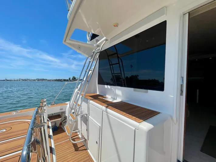 My Way Yacht Photos Pics 1998 Viking 50 Convertible yacht deck with ladder, overlooking calm waters and clear sky.