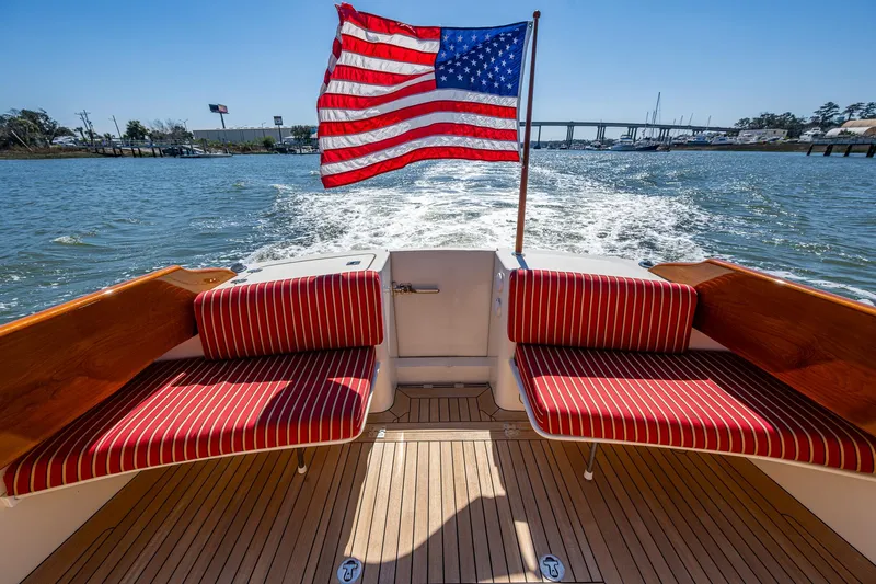 Double Expresso Yacht Photos Pics Hinckley Talaria 44 MY 2006 boat with American flag, red-striped seating, cruising on water.