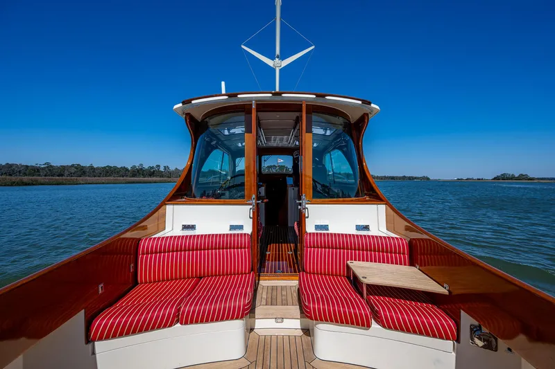 Double Expresso Yacht Photos Pics 2006 Hinckley Talaria 44 MY yacht with red-striped seating on calm water.