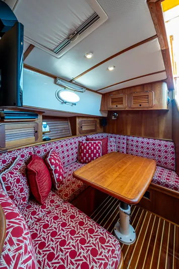 Double Expresso Yacht Photos Pics Interior of 2006 Hinckley Talaria 44 MY with red patterned seating and wooden table.