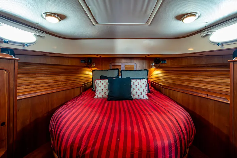 Double Expresso Yacht Photos Pics Luxurious 2006 Hinckley Talaria 44 MY cabin with red-striped bedding and elegant wood paneling.