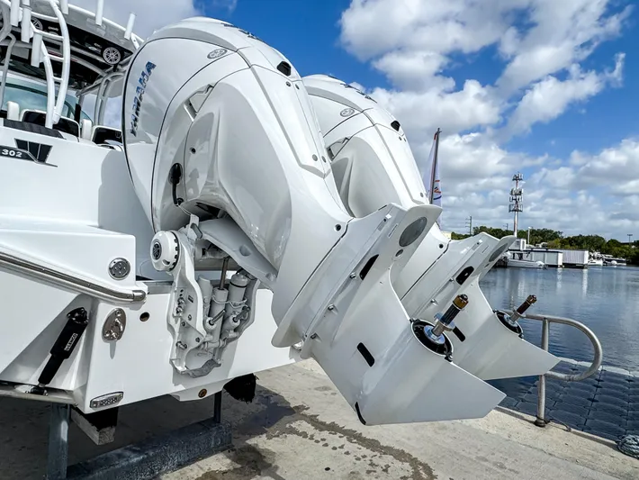  Yacht Photos Pics 2025 Wellcraft 302 Fisherman boat with dual outboard engines at a marina.
