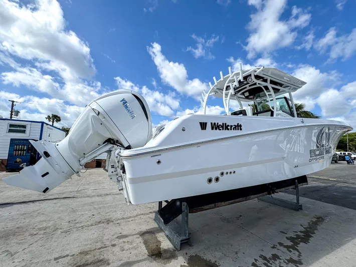  Yacht Photos Pics 2025 Wellcraft 302 Fisherman boat on display under a partly cloudy sky.